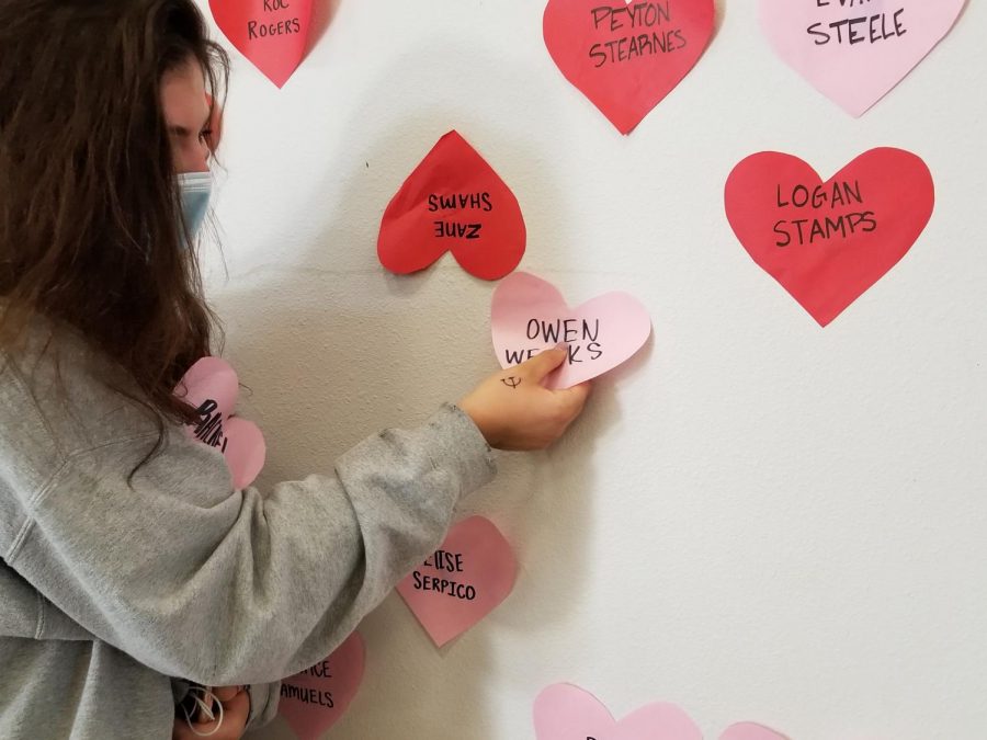 STEALING HEARTS Katie Hofmann (10) grabs freshman Owen Weeks heart Friday morning, one of more than 1,600 hearts hung by Student Council the night before. Its a great tradition...it helps us feel normal, Hofmann said. And it gives us a chance to let our friends know how we feel.