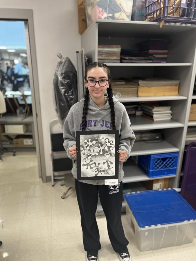 CREATIVE COMPOSITION: Junior Gretchen Bagby presented art she drew in Mrs. Wilkins art class and which was inside of DMs art gallery. Mrs. Wilkins says she enjoys teaching art. “It’s my joy, my joy everyday,” she said. Desert Mountain takes pride in the art of this school, and in fact various galleries and murals throughout the school display students art.