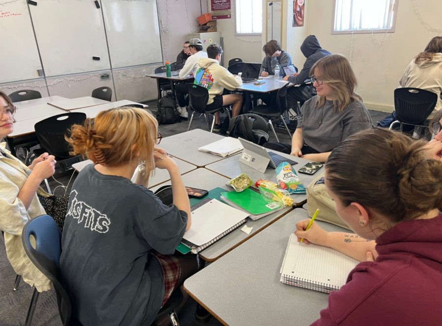 MATHIN & SNACKIN: Students Mila Jaramazovic (11), Aubrey Hart (11), Sophie Galitsky (11), Sophie Seratte (11) learn how to factor rational functions and revise the rules of division when applied. in Mrs. Moskovich’s Algebra II class. “I love being able to communicate and collaborate with my peers,” said sophomore Peter Cipra (not pictured), an active participant in the class. Mrs. Mosckovich’s Algebra II class had a quiz the day before and were linking those concepts to new ones, with a snack or two. 