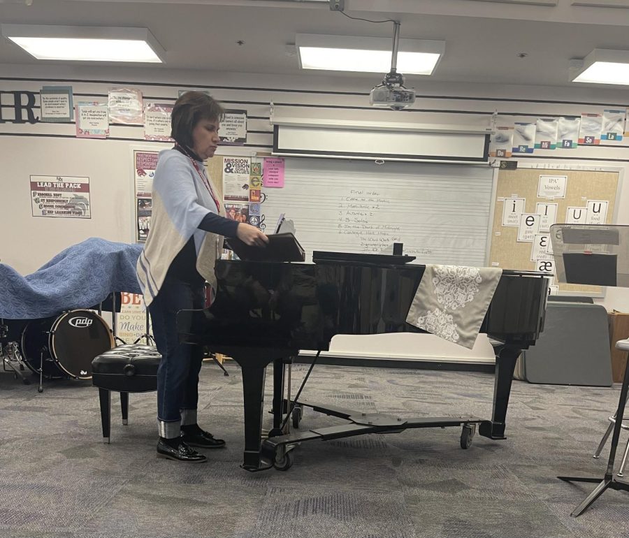 A CRESCENDO OF PRACTICE: Ms.Jennifer Moore, who teaches the piano class, sets up the piano in order to start the recital where students play their musical pieces. "“Most people are progressing fine to learn how to play the piano. But it takes time, and how much time you put in, that's how much you get out. If you don’t put in any time into it you won’t play,” said Ms.Moore. With the parent recital coming up in early April, Ms.Moore says that students will start practicing what they are going to play in front of their parents. 